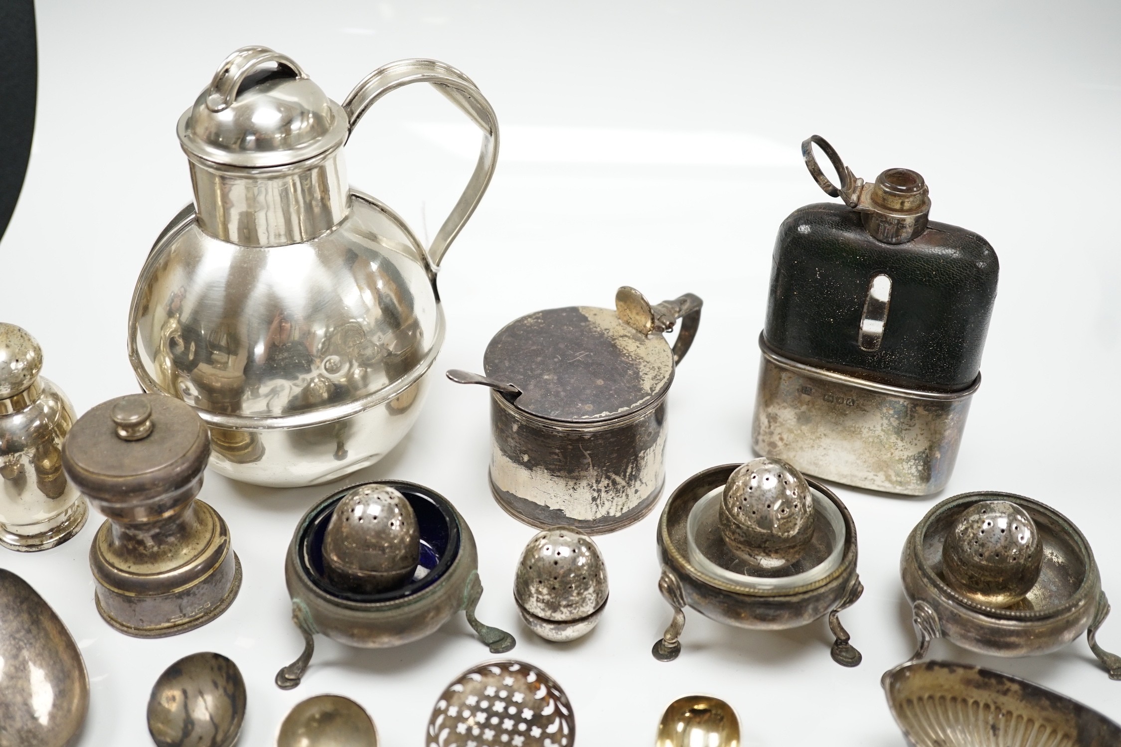 Sundry small silver including a Guernsey can milk jug, mustard pot, damaged mounted glass hip flask, flatware and minor plated wares.